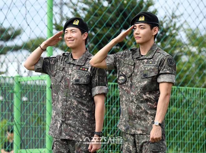 방탄소년단(BTS)의 RM(왼쪽, 김남준)과 뷔(김태형)가 10일 강원도 춘천시 신북읍 체육공원에서 진행된 전역 행사에서 팬과 취재진을 향해 거수 경례를 하고 있다. 춘천 | 박진업 기자 upandup@sportsseoul.com