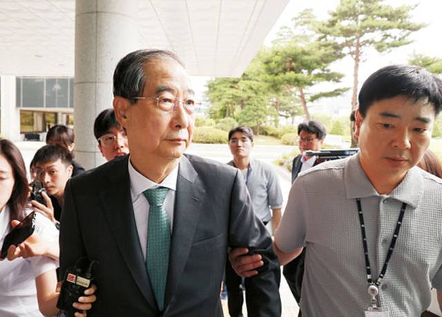 착잡한 韓 전총리 : 한덕수(가운데) 전 국무총리가 2일 오전 내란특검팀 수사관의 손에 이끌려 특검 사무실이 있는 서울 서초구 서울고검 청사로 들어서고 있다. 뉴시스