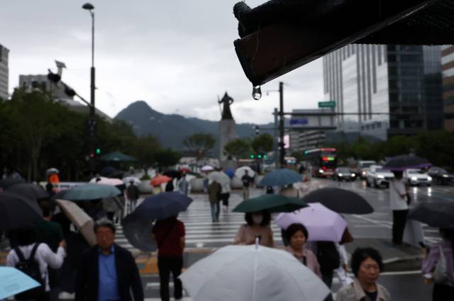 지난달 25일 오전 서울 세종로사거리에서 시민들이 우산을 쓴 채 길을 걷고 있다. 연합뉴스