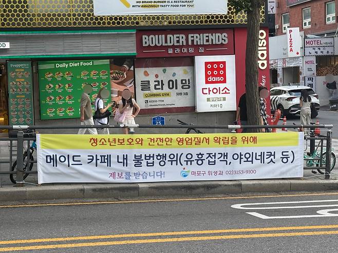 1일 서울 마포구 서교동 홍익대학교 일대에 '청소년 보호와 건전한 영업질서 확립을 위해 메이드 카페 내 불법행위(유흥접객, 야외네컷 등) 제보를 받습니다'라는 현수막이 걸려있다. /이호준 기자