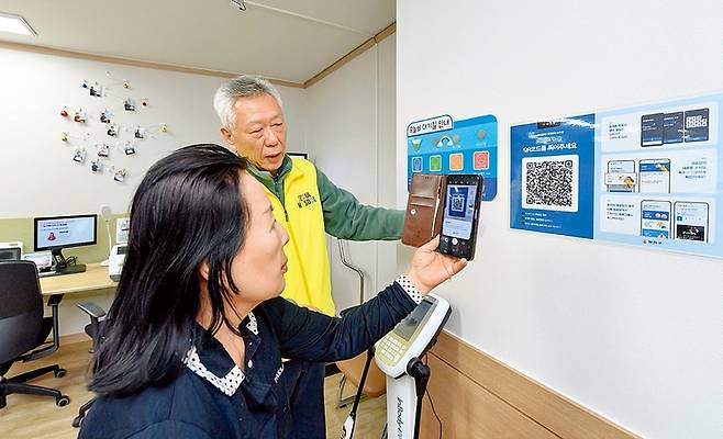 경로당 운영진이 경로당 모바일 시스템에 정보무늬(QR코드)로 접속하고 있다. 양천구 제공