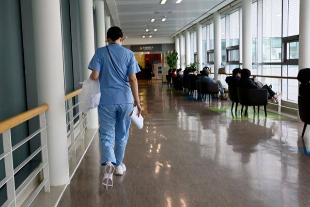 연명의료결정제는 7년 전 시행됐지만, 아직 모든 병원 환자가 이용할 수 있는 상태는 아니다. 이 공백을 보완하기 위해 설치된 것이 전국공용윤리위원회이지만, 전국 담당자는 13명에 불과하고 이들 중 다수는 비정규직 신분이었다. 사진은 지난해 서울의 한 상급종합병원에서 간호사가 복도를 분주히 이동하고 있는 모습. 한국일보 자료사진