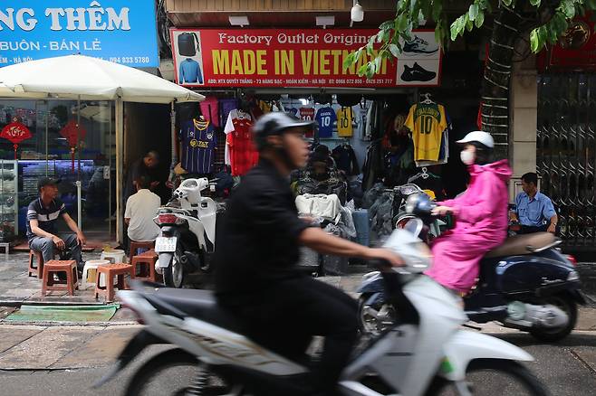 오토바이를 탄 사람들이 3일 베트남 하노이의 한 거리에 있는 ‘베트남산’이란 간판이 붙은 매장 앞을 지나가고 있다. EPA연합뉴스