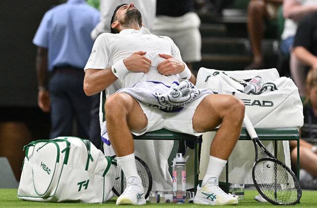노바크 조코비치(6위·세르비아)가 2일(한국시간) 영국 런던 올잉글랜드클럽에서 열린 윔블던 남자 단식 1회전 알렉상드르 뮐러(41위·프랑스)와 경기 도중 복통으로 타임아웃을 요청한 뒤 약을 먹고 배를 만지며 안정을 취하고 있다. 조코비치는 이날 뮐러를 3대 1로 꺾었다. AFP연합뉴스