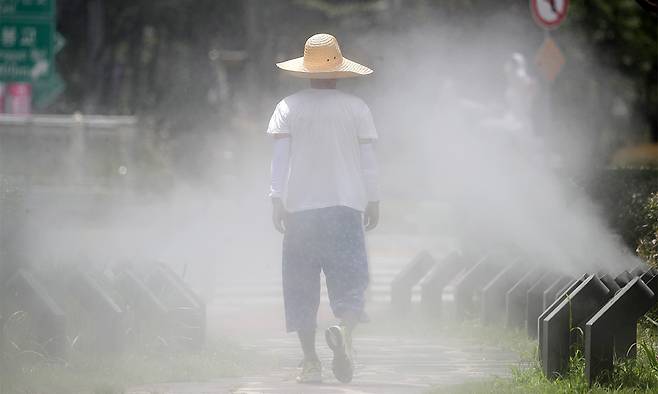 지난 3일 대구 중구 김광석길 입구에 가동된 쿨링포그 사이로 밀짚모자와 쿨토시, 반바지 차림의 시민이 걷고 있다. 뉴스1