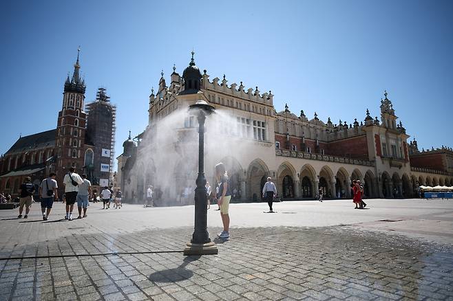 7월 2일 폴란드 크라쿠프에서 한 어린이가 공공 스프링클러에서 나오는 쿨링 포그로 더위를 식히고 있다 /EPA 연합뉴스