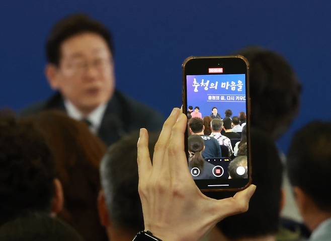 4일 대전컨벤션센터에서 열린 '충청에서 듣다, 충청 타운홀 미팅'에서 참석자들이 이재명 대통령의 발언 모습을 촬영하고 있다. /뉴시스