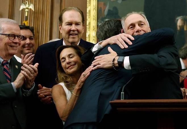 미국 하원 의장 마이크 존슨(공화당·루이지애나주)이 하원 공화당 회의 의장 리사 맥클레인 의원(공화당·미시간주)이 하원 공화당 의원들과 함께 포옹하며 OBBBA 법안 통과를 기뻐하고 있다. AFP연합뉴스