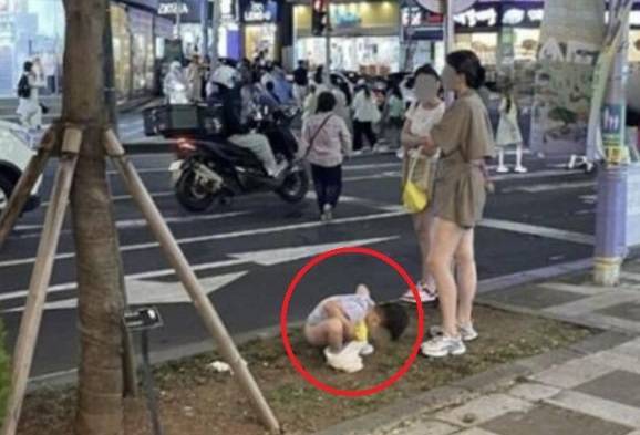 제주시의 한 거리에서 대변을 보고 있는 중국인 아이와 보호자의 모습 (사진, 온라인 커뮤니티)