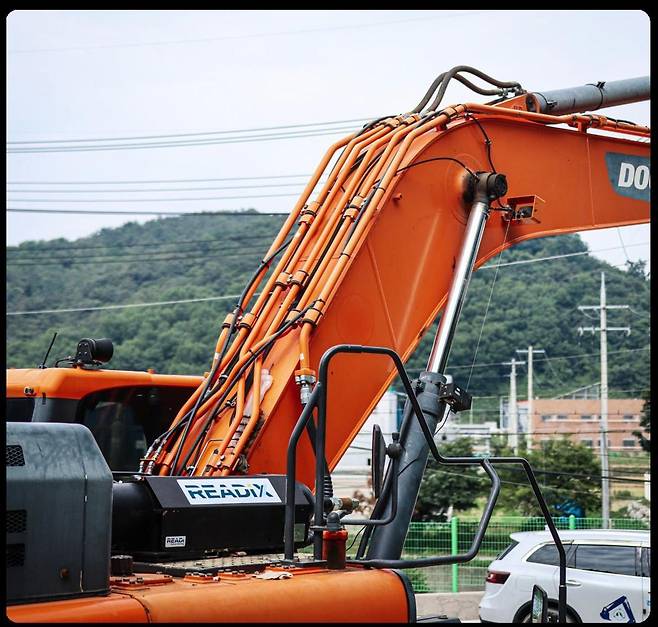 레디로버스트머신의 에너지 회수 장치가 굴착기에 부착된 모습. 레디엑스(READiX) 글자가 보이는 부분이 회수 장치다. 레디로버스트머신 제공