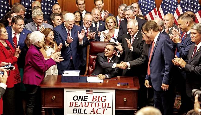 < 美 하원의장, 감세안 서명 > 마이크 존슨 미국 하원의장이 3일 의회의사당에서 도널드 트럼프 대통령의 핵심 정책을 담은 ‘하나의 크고 아름다운 법안’에 서명한 뒤 동료 의원과 악수하고 있다. /로이터연합뉴스