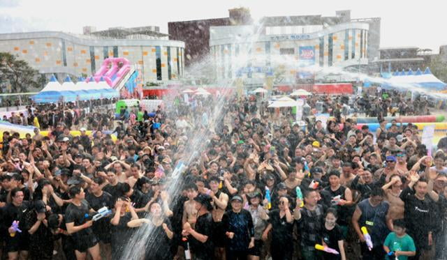 2024 보령 머드축제 ‘머드흠뻑존’ 참가자들이 온몸에 머드를 바른 후 물대포를 맞으며 즐거워하고 있다 / 사진=보령시