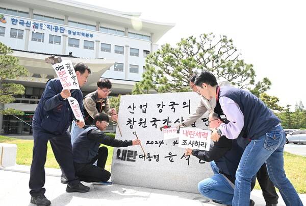 민주노총 경남지역본부가 2025년 4월 21일 오후 창원시 성산구 한국산업단지공단 경남지역본부 앞에서 윤석열 휘호석 철거 촉구 기자회견을 하고 있다. 기자회견 후 망치와 정을 이용해 철거 요구 퍼포먼스를 하고 있다. /김구연 기자