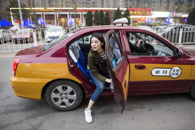 중국 베이징에서 한 여성이 택시를 하차하고 있다. (사진=AFP)