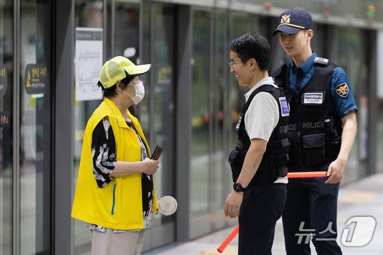 신창훈 지하철경찰대 안전계장이 2일 서울 성동구 왕십리역 승강장을 순찰하다 장애인 안내도우미와 대화하고 있다. 2025.7.2 ⓒ 뉴스1 이승배 기자