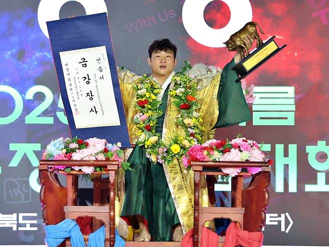 7일 충북 보은국민체육센터에서 열린 위더스제약 2025 민속씨름 보은장사씨름대회 금강장사 결정전에서 우승을 차지한 김기수(수원특례시청)가 장사 인증서와 황소 트로피를 들고 꽃가마에 올라 기념사진을 찍고 있다.