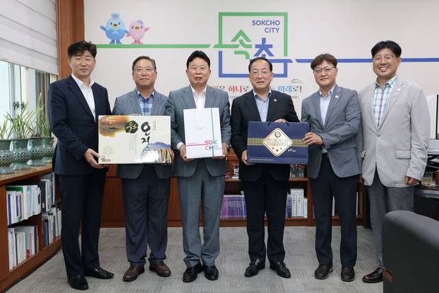 서태원(왼쪽 세번째) 가평군수와 이병선(왼쪽 네번째) 속초시장 등이 지난 4일 속초시청에서 차담회를 갖고 각 지방자치단체 특산품 중 하나인 오징어와 막걸리를 교환하고 있다. 가평군 제공