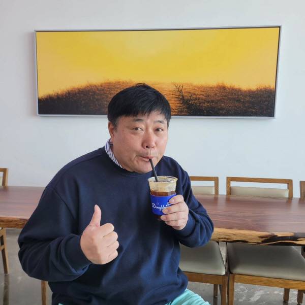 카페 '동끝'의 시그니처 컵을 들고 커피를 마시는 양준혁 대표.