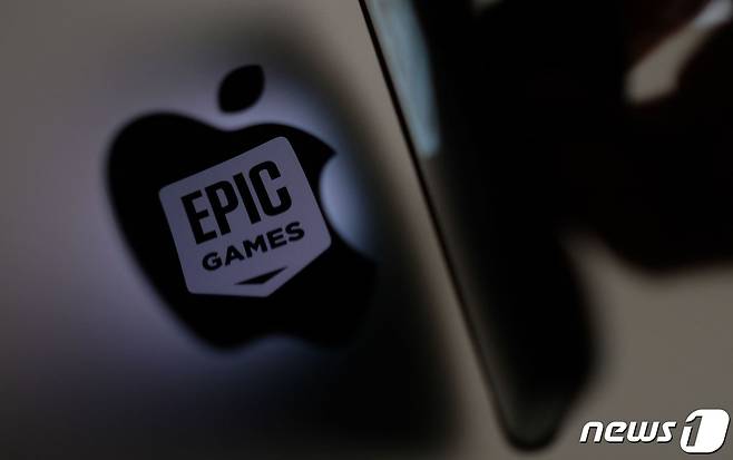 (FILES) This illustration photo shows the Epic Games logo reflecting onto the Apple logo of the back of an I-mac in Los Angeles on May 3, 2021 (Photo by Chris DELMAS / AFP) ⓒ AFP=뉴스1