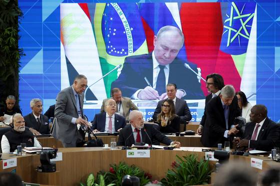 블라디미르 푸틴 러시아 대통령이 6일(현지시간) 브라질 리우데자네이루 현대미술관에서 열린 브릭스 정상회의 개막 회의에 원격으로 참석하는 모습이 화면에 나오고 있다. 이 회의에는 루이스 이나시우 룰라 다시우바 브라질 대통령, 나렌드라 모디 인도 총리, 시릴 라마포사 남아프리카공화국 대통령이 참석했다. 로이터=연합뉴스