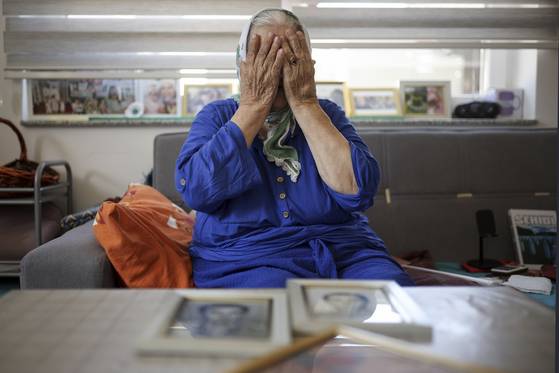 89세의 보스니아 여성이 스레브레니차 학살 때 희생당한 두 아들의 사진을 보이며 고통스러워하고 있다. AP=연합뉴스