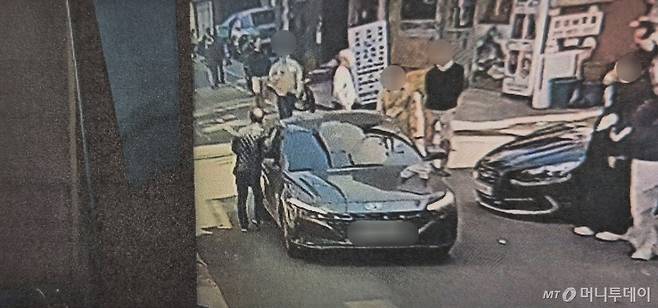 지난해 4월 1일 종로구 동묘공원 인근에서 A씨가 지나가는 차량 사이드미러에 오른팔을 부딪치는 모습. /사진제공=서울혜화경찰서