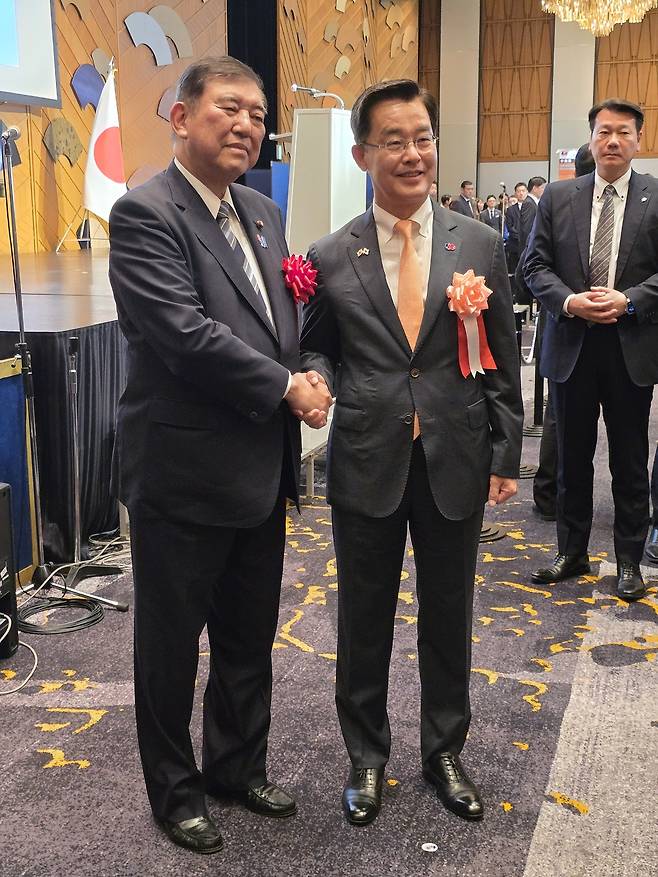 이시바 시게루 일본 총리(왼쪽)가 지난달 19일 도쿄 뉴오타니호텔에서 열린 ‘한·일 국교정상화 60주년 기념 리셉션’에 참석해 박철희 주일 한국대사와 손을 잡고 기념촬영을 하고 있다. 주일 한국대사관 제공