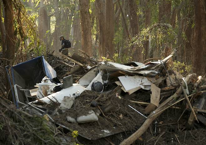 8일(현지시간) 폭우 피해가 발생한 미국 텍사스 중부 지역 커 카운티에서 한 자원봉사자가 인근을 수색하고 있다. AP연합뉴스