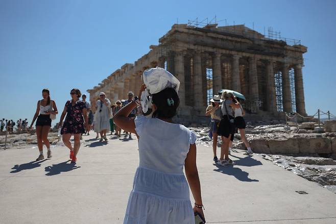 그리스 아테네 아크로폴리스가 폐쇄되기 전날인 7일(현지시간) 한 여성이 햇빛을 막기 위해 머리를 가리고 있다. 로이터연합뉴스