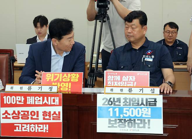 최저임금위원회 사용자위원인 류기정 한국경영자총협회 전무(왼쪽)와 근로자위원인 류기섭 한국노총 사무총장이 8일 정부세종청사에서 열린 최저임금위원회 제10차 전원회의에서 나란히 앉아 얘기를 나누고 있다. 연합뉴스