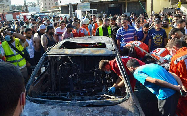 레바논 당국이 2025년 7월 8일 북부 트리폴리 지역에서 이스라엘 공습으로 타버린 차량을 살피고 있다. AFP 연합뉴스