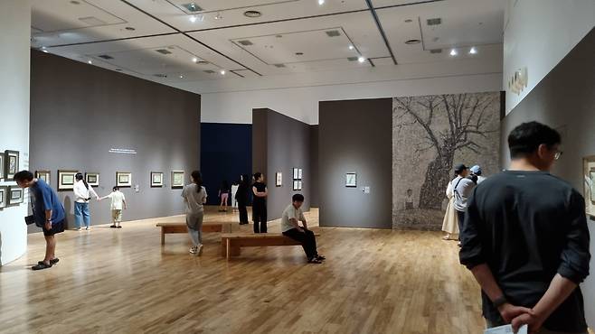 전시장에서 유명 화가의 작품을 감상하는 사람들.