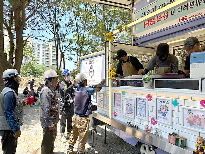 HS화성은 10일 달성군의 공사 현장에 간식차를 보내 근로자들이 컵빙수 등으로 폭염 속 더위를 식힐 수 있도록 했다. <HS화성 제공>