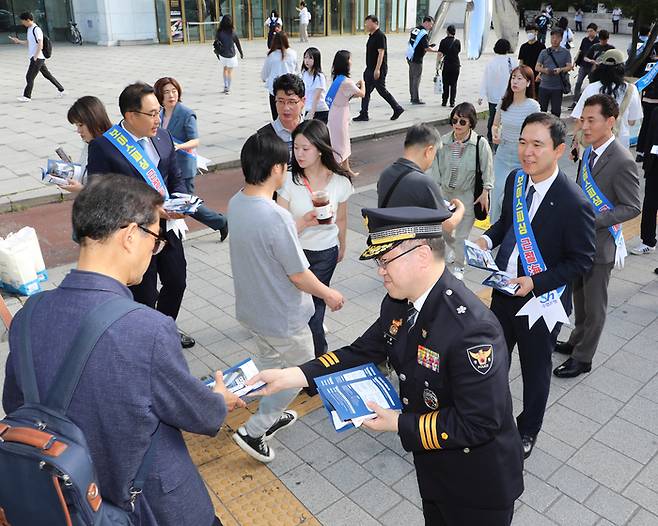 신학기 Sh수협은행장(오른쪽 두 번째)이 김용종 서울송파경찰서장과 함께 출근길 시민들에게 보이스피싱 범죄유형과 수법, 대응요령, 후속 조치사항 등 자세한 피해예방 안내가 담긴 리플렛과 홍보물을 나눠주는 캠페인을 진행하는 모습. 사진제공=Sh수협은행