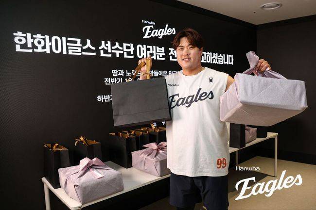 한화 류현진이 김승연 회장에게 받은 선물을 들며 웃고 있다. /한화 이글스 제공