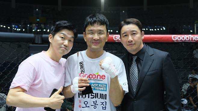 개그맨 파이터 윤형빈(가운데)이 지난달 28일 서울 장충체육관에서 열린 ‘굽네 로드FC 073’에서 유튜버 밴쯔를 상대로 승리한 뒤 로드FC 정문홍 회장(오른쪽), 김앤장 법률사무소 박민철 변호사와 함께 사진촬영을 하고 있다. 사진제공|로드FC