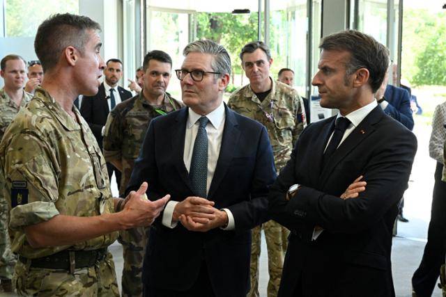 영국을 국빈 방문 중인 에마뉘엘 마크롱(오른쪽) 프랑스 대통령이 키어 스타머(가운데) 영국 총리와 함께 10일 런던 북서부에 위치한 해양 지휘 센터(MARCOM)를 방문해 설명을 듣고 있다. 런던=로이터 연합뉴스