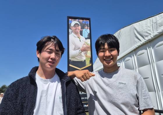 이유준(왼쪽)과 이정우가 제네시스 스코티시 오픈 2023년 우승자 로리 매킬로이의 휘장 앞에서 포즈를 취하고 있다. 성호준 기자