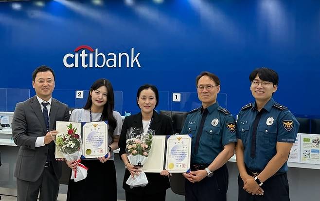 한국씨티은행은 경인영업부 소속 직원 2명이 보이스피싱 범죄를 현장에서 인지하고 경찰 신고를 통해 인출책 검거에 기여한 공로로 인천남동경찰서로부터 감사장을 수여받았다고 10일 밝혔다. 왼쪽 두번째부터 이 모 행원과 양 모 수석이 기념촬영하고 있다. <한국씨티은행>