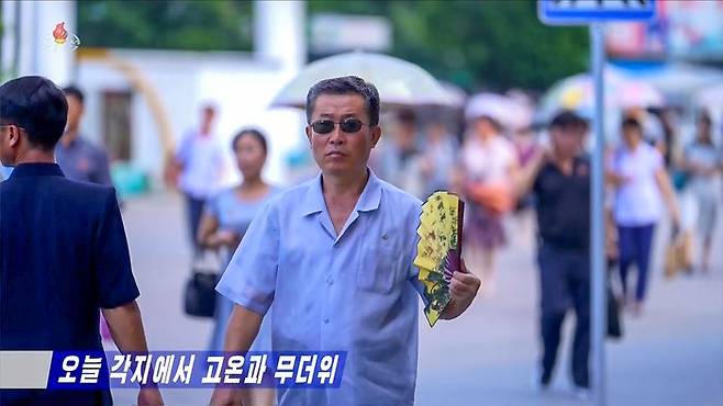 무더위가 지속되는 북한 평양에서 한 남성이 부채질을 하며 더위를 식히고 있다. ⓒ조선중앙TV·연합뉴스