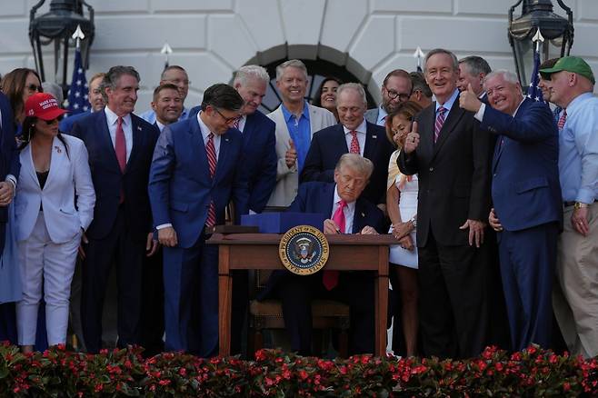 4일 서명식에서 법안에 서명하는 트럼프 대통령을 바라보며 밝은 표정을 짓고 있는 공화당 의원들. 워싱턴=AP 뉴시스