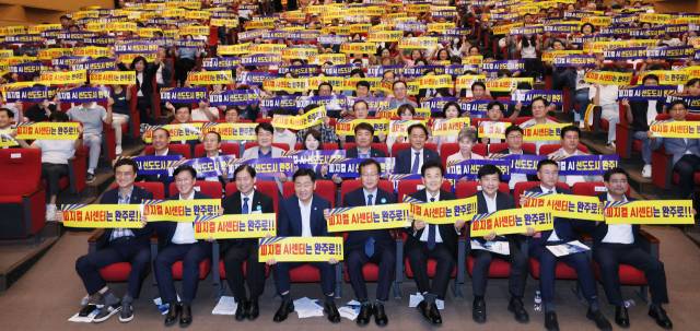 ▲11일 전북 완주군청 문예회관에서 열린 ‘피지컬AI 모빌리티 실증 선도사업 전북 세미나’에서 참석자들이 ‘피지컬 AI센터는 완주로!’라고 적힌 손팻말을 들고 구호를 외치고 있다. ⓒ프레시안