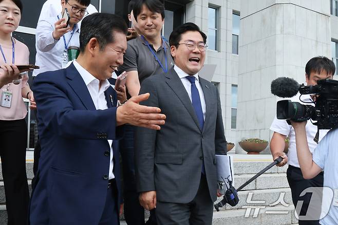 더불어민주당 당대표에 도전하는 정청래(왼쪽), 박찬대 의원이 2일 오후 서울 여의도 국회에서 검찰개혁 토론회 축사를 마친 뒤 함께 손을 잡고 걸어가며 취재진 질문을 받고 있다. 2025.7.2/뉴스1 ⓒ News1 안은나 기자