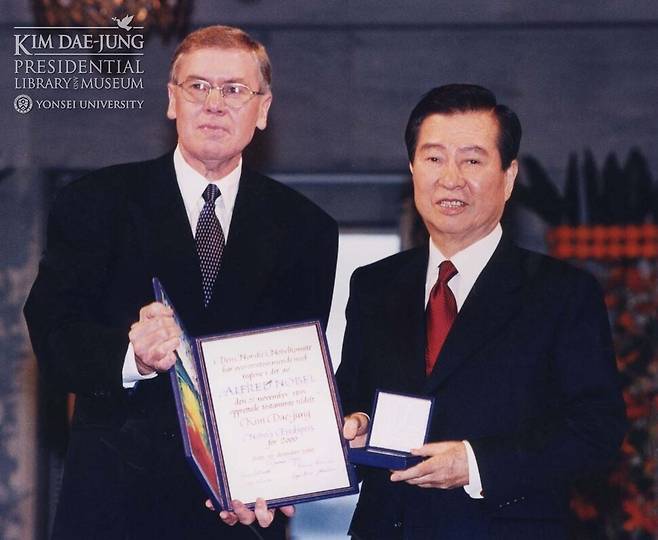 2000년 12월 김대중 전 대통령(오른쪽)이 노르웨이 오슬로에서 열린 노벨평화상 시상식에서 군나르 베르게 노르웨이 노벨위원회 위원장에게 노벨평화상 메달과 상장을 수여받고 있다. 김대중평화센터 누리집 갈무리