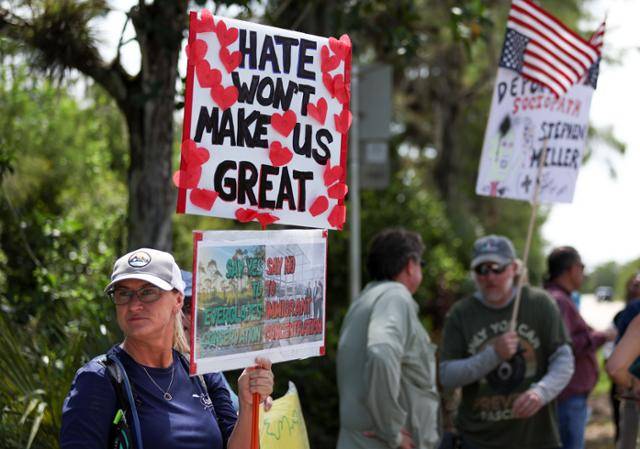 '혐오는 우리를 위대하게 만들지 않는다'는 내용의 피켓을 든 시위자가 12일 미국 플로리다 오초피에 있는 이민자 구금 시설 앞에 서 있다. 오초피=AP 연합뉴스