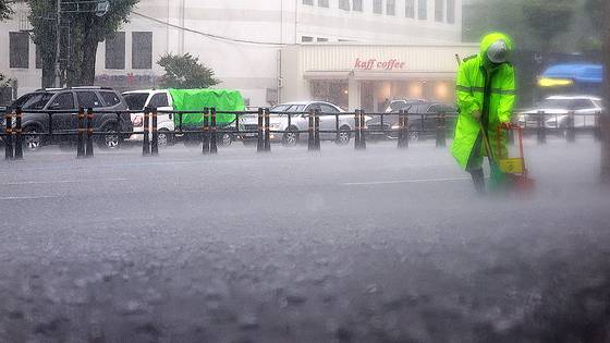 지난달 16일 폭우가 쏟아진 서울 서대문구에서 환경미화원이 인도를 청소하고 있다. 연합뉴스