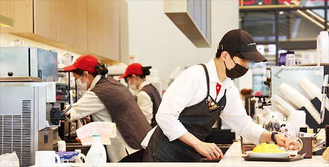 < “바쁘다 바빠” > 2026년 최저임금이 올해보다 290원 오른 1만320원으로 결정돼 최저임금의 80%로 책정되는 실업급여 하한액이 10년 만에 상한액(하루 6만6000원)을 추월했다. 13일 서울 시내 한 카페에서 종업원이 음식을 만들고 있다. 연합뉴스