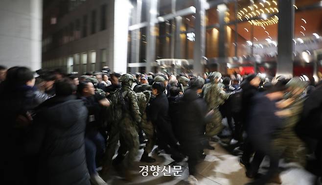 윤석열 전 대통령의 12·3불법계엄을 선포한 다음 날인 지난해 12월4일 계엄군이 서울 여의도 국회 본관으로 진입을 시도하자 시민들이 서로 손을 잡고 저지하고 있다. 한수빈 기자