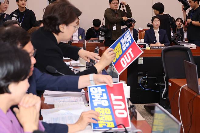  14일 국회 여성가족위원회에서 열린 강선우 여성가족부 장관에 대한 인사청문회에서 국민의힘 의원들이 강 후보자 사퇴를 요구하는 피켓을 여당의 항의가 이어지자 떼어내고 있다. ⓒ연합뉴스
