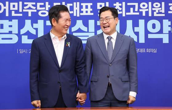 더불어민주당 대표 선거 후보인 정청래 의원(왼쪽)과 박찬대 의원이 15일 국회에서 열린 당 대표 공명선거실천서약식에서 기념촬영을 하고 있다. 임현동 기자